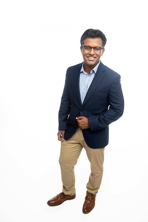Studio portrait of MSU engineering student Mayukh Datta wearing a blue blazer and standing in front of a white background