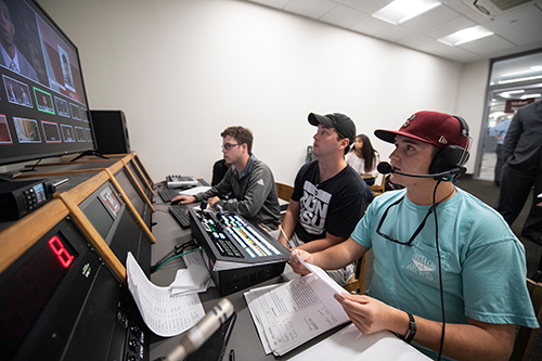 Three students work in the control room of Mitchell Memorial Library’s MaxxSouth Digital Media Center