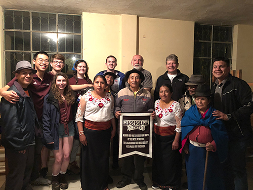 Students in MSU’s Engineers Without Borders chapter stand with MSU faculty and staff members, as well as Santa Teresita residents holding an MSU flag.