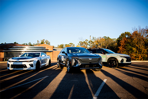 MSU’s newest EcoCAR is a Cadillac LYRIQ, center, pictured by two vehicles that MSU student team members have worked on during earlier iterations of North America’s premier collegiate automotive engineering competition sponsored by the U.S. Department of Energy, General Motors and MathWorks.