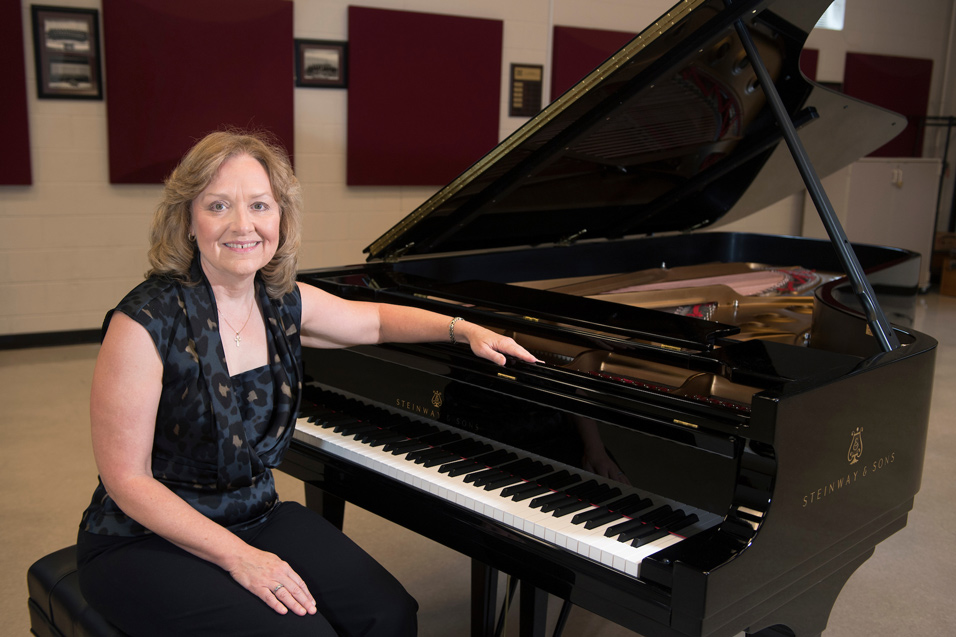 Jackie Edwards-Henry is pictured with a brand new Steinway & Sons piano recently purchased for the Department of Music’s All-Steinway Initiative. (Photo by Beth Wynn)