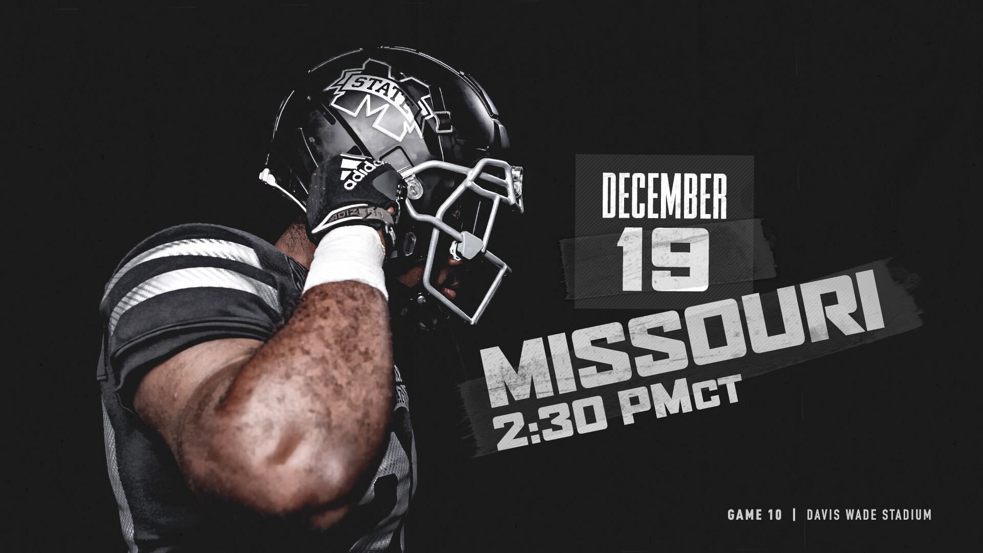 A Mississippi football player in a black uniform is pictured adjusting his black helmet.