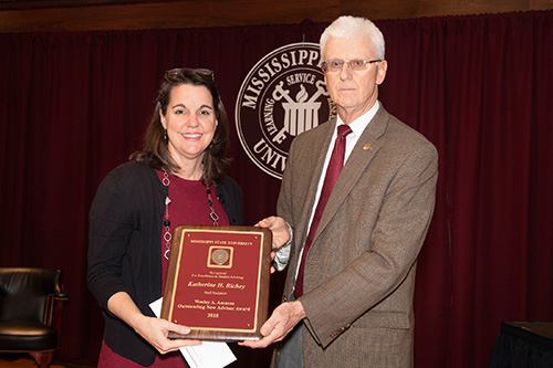 Peter Ryan, MSU associate provost for academic affairs, congratulates Katherine Richey, staff recipient of the Wesley A. Ammon Outstanding New Advisor Award. (Photo by Beth Wynn)