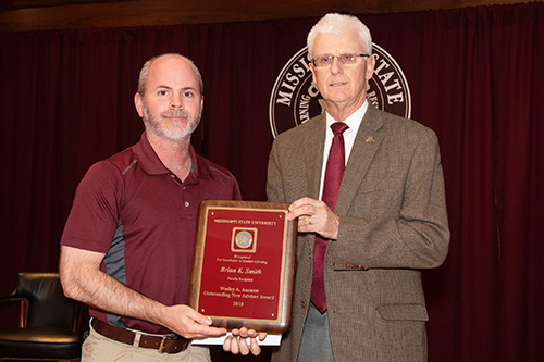Peter Ryan, MSU associate provost for academic affairs, congratulates Brian K. Smith, faculty recipient of the Wesley A. Ammon Outstanding New Advisor Award. (Photo by Beth Wynn)
