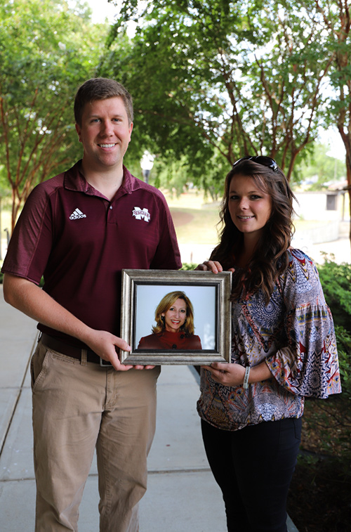 Connor Ferguson, left, an MSU assistant professor of plant and soil sciences, and Sarah Morrow, an MSU College of Education senior educational psychology major from Corinth, hold a photograph of Ferguson’s mother. Morrow is the first recipient of the Yvonne R. Ferguson Memorial Scholarship, established by Connor Ferguson to honor his late mother’s legacy as a single parent by “paying it forward” to students who mirror her success. (Photo by Taylor Bigham)
