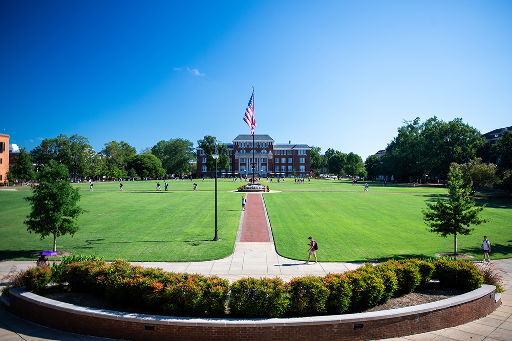 Students walk across the Drill Field on a sunny day at MSU