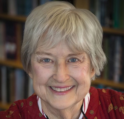 Portrait of author Frances Robb smiling with bookshelves in the background