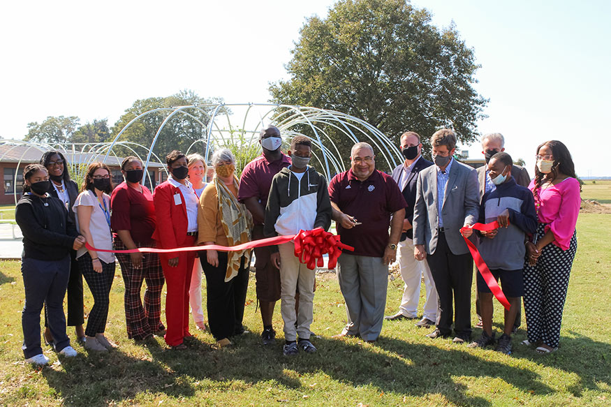 A group of students, teachers, administrators and partners celebrate a ribbon cutting at Leland School Park