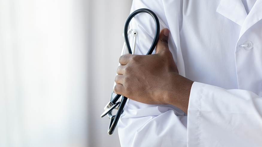 Close-up picture of a doctor's hand holding a stethoscope.