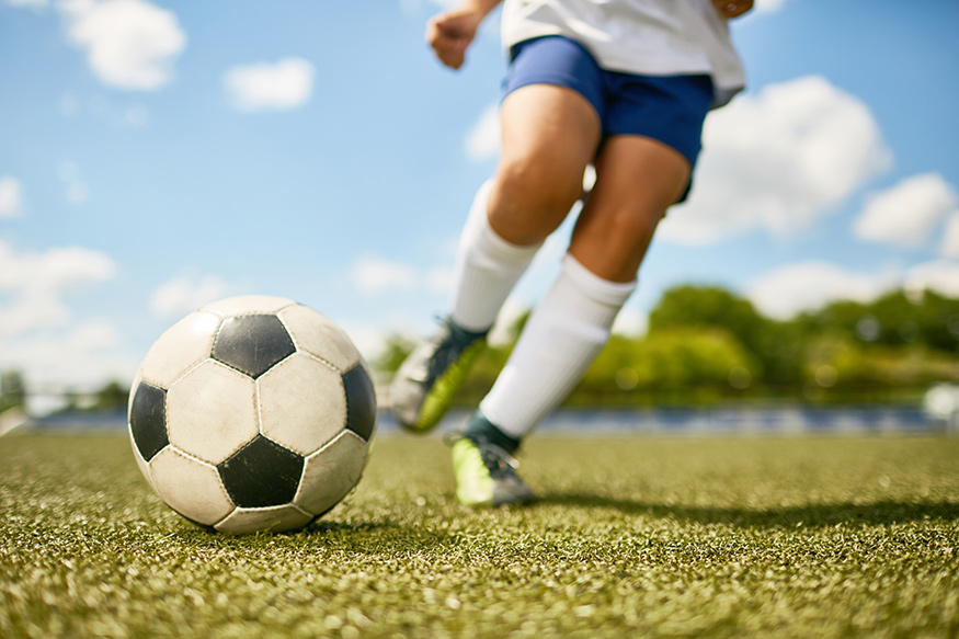 An up close photo of someone about to kick a soccer ball