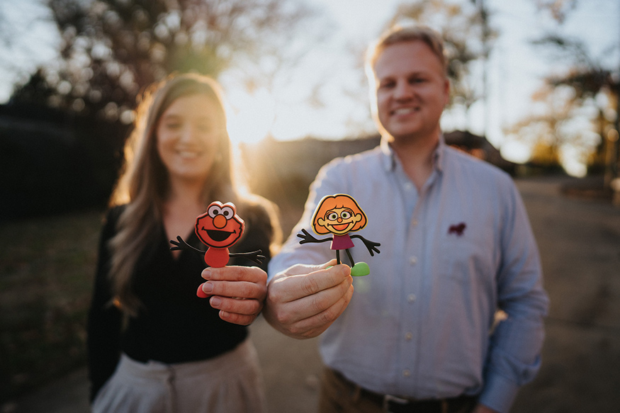 Anna Barker and Hagan Walker hold Elmo and Julia Glo Pal characters.