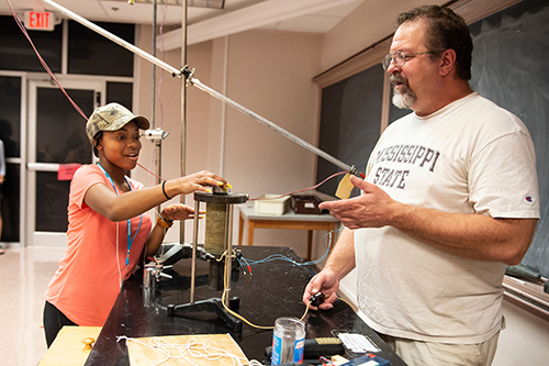 Kristen Ellis, a senior at Holmes County Central High School, assists with a demonstration from Jeff Allen Winger, a Mississippi State University professor of nuclear physics. Winger’s demonstrations are part of the AP physics preparatory academy at Mississippi State. (Photo by Logan Kirkland)