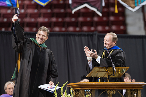 Dr. Allen K. Sills Jr., left, rings a cowbell presented by MSU President Mark E. Keenum, right, after the morning commencement address Friday [Dec. 8]. (Photo by Megan Bean) 