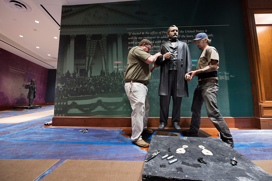 Waverly Oakley, left, MSU Libraries building services coordinator, and BJ Ervick, production director for Brooklyn-based Studio EIS, install one of four life-size Ulysses S. Grant statues recently at the Grant Presidential Library in MSU’s Mitchell Memorial Library. Each of the statues represents a phase of Grant’s life. (Photo by Megan Bean)