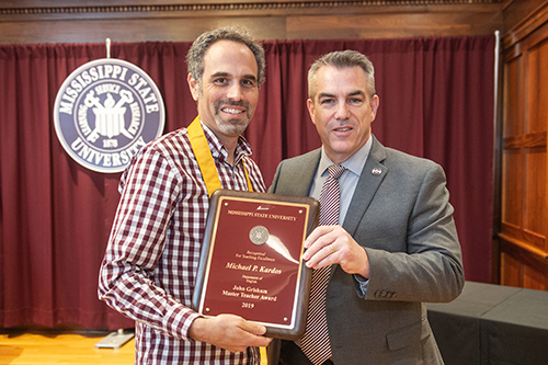 MSU Associate Professor of English Michael Kardos receives the university’s John Grisham Master Teacher Award from Jim Dunne, physics professor and interim associate vice president for academic affairs. (Photo by Megan Bean)