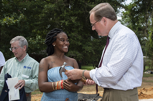 MSU President Mark E. Keenum gives a hammer to Lou-Quan Lucious, who will be the owner of the tenth Maroon Edition Habitat for Humanity home, during Tuesday’s [Aug. 14] groundbreaking ceremony. (Photo by Logan Kirkland)