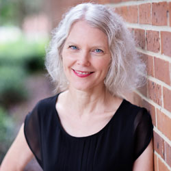 Becky Hagenston leaning against a brick wall