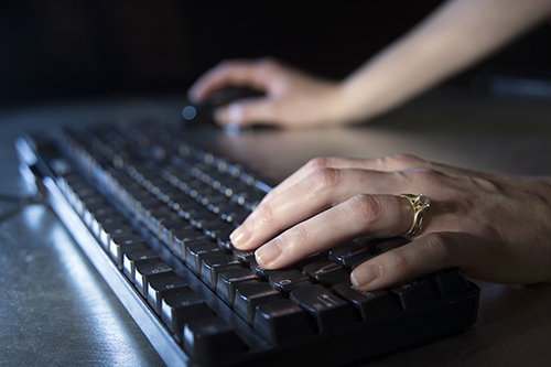 Hands type at a keyboard