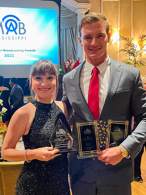 MSU graduates Hannah Vanderberg and Bronson Woodruff smile while holding awards from the Mississippi Association of Broadcasters.
