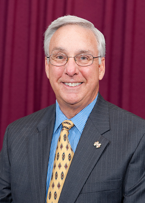 Portrait of Danny Hossley with maroon background