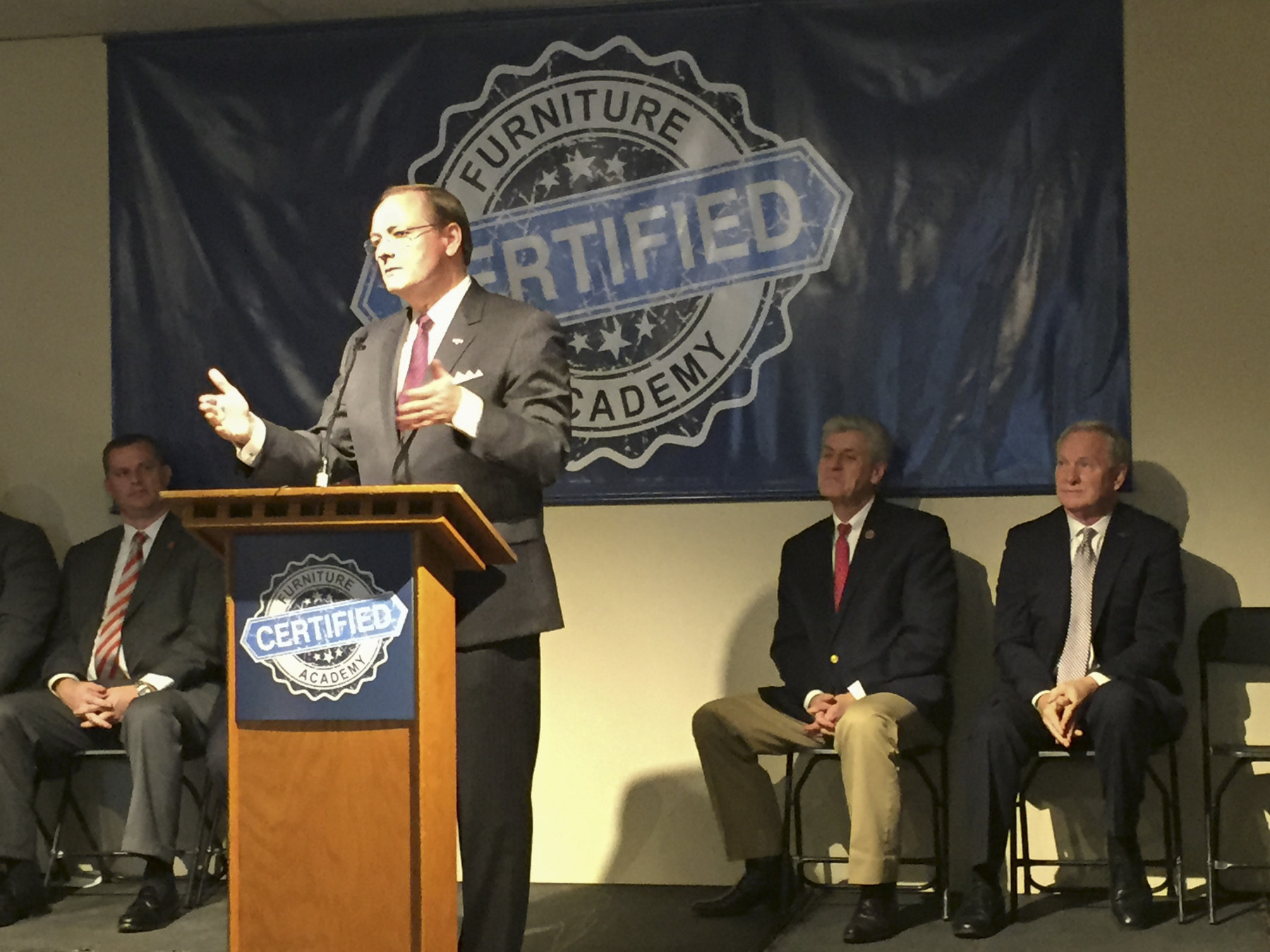 Mississippi State President Mark E. Keenum (standing) discusses the university's role in the Furniture Academy during a press conference in Tupelo Thursday morning [Jan. 12].