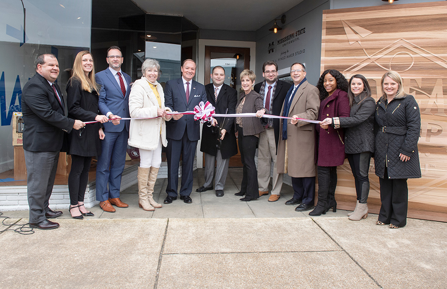 MSU and city of Starkville officials cut the ribbon to officially open the MSU Idea Shop, a new downtown makerspace and retail storefront. Pictured, from left, are Michael Newman, director of the MSU School of Human Sciences; Lori Neuenfeldt, instructor of art; Charles Freeman, associate professor of fashion design and merchandising; Starkville Mayor Lynn Spruill; MSU President Mark E. Keenum, Michael Lane, Idea Shop program coordinator; Sharon Oswald, dean of the MSU College of Business; Eric Hill, director of the MSU Center for Entrepreneurship and Outreach; Jeffrey Rupp, MSU College of Business Outreach Director; Karissa Logan and MacKenzie Hightower, Idea Shop retail managers and MSU graduate students; and Jennifer Prather, Interim CEO of the Greater Starkville Development Partnership. (Photo by Beth Wynn)