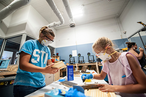 Sisters Ali Grace Williams and Audrey Caroline Williams apply varnish to wood during a 2019 Father’s Day gift-making workshop at MSU’s Idea Shop.