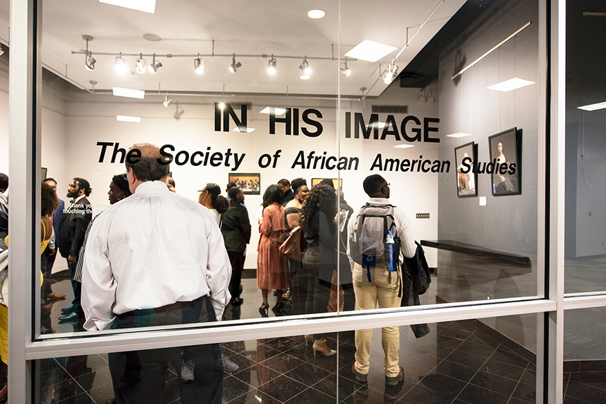 Students and others browse photographs in MSU’s “In His Image” exhibition at Colvard Student Union.
