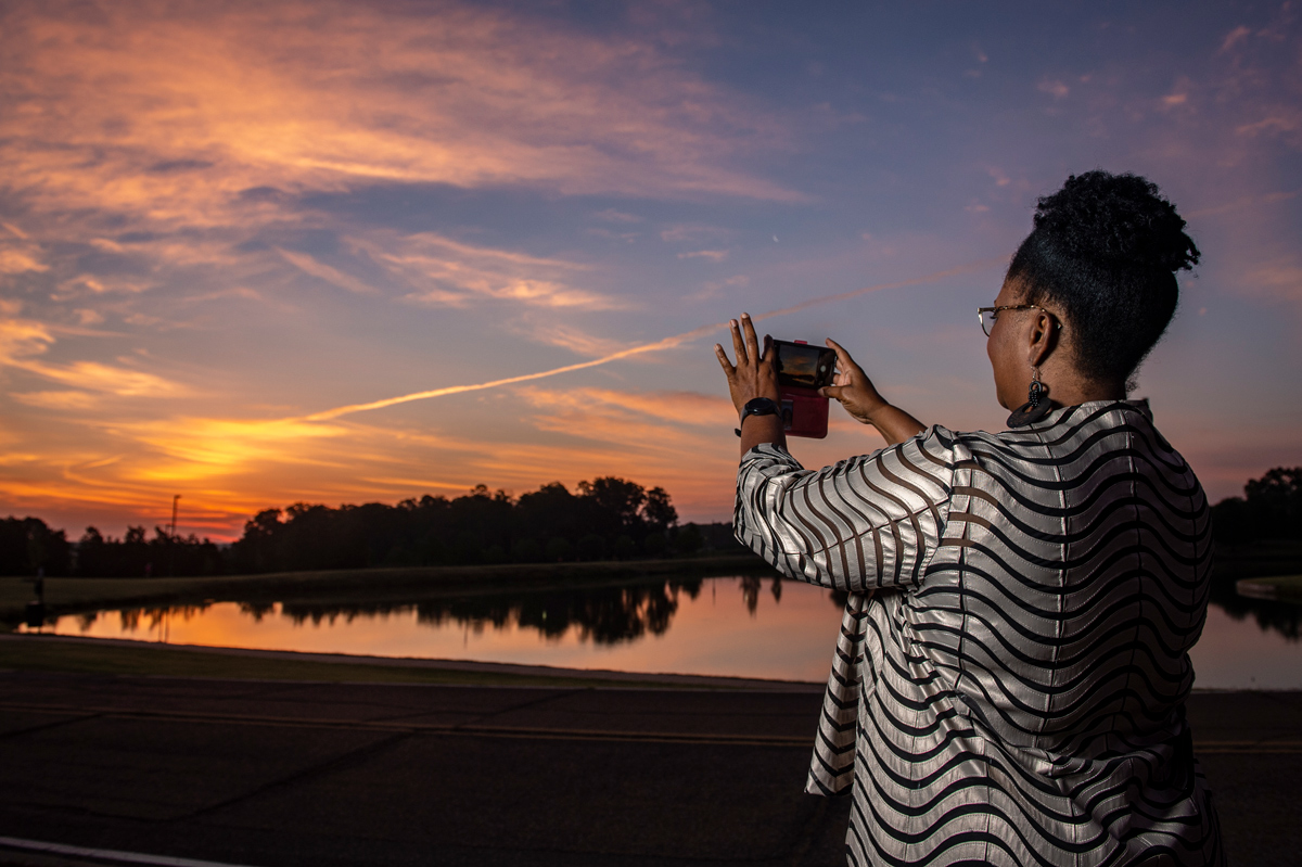 Jennie Griffin takes a picture of a sunrise at Chadwick Lake
