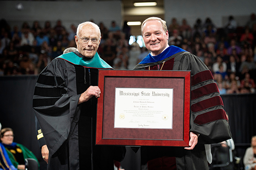 Kenneth D. Johnson, left, receives an honorary Doctor of Public Service degree from MSU President Mark E. Keenum during Friday [May 3] afternoon commencement ceremonies at Mississippi State University. A Leake County native and Ridgeland resident, the decorated veteran has been a longstanding supporter of MSU’s College of Forest Resources and continues to mentor student veterans and active-duty service members. (Photo by Megan Bean)