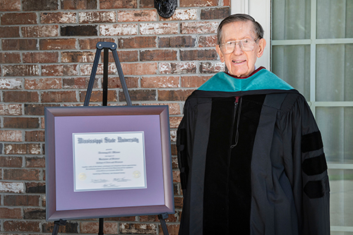 The Honorable John J. Fraiser Jr. is pictured with the Doctor of Public Service honorary degree, the university’s highest honor