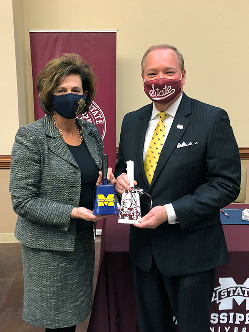 Mark Keenm and Mary Graham display MSU and MGCC cowbells.