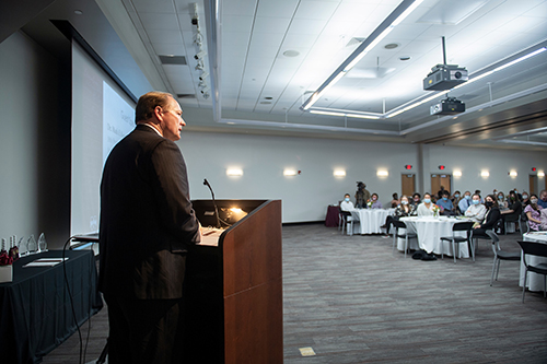 MSU President Mark E. Keenum stands at a podium while speaking to attendees at the MSU Graduate Awards Ceremony.