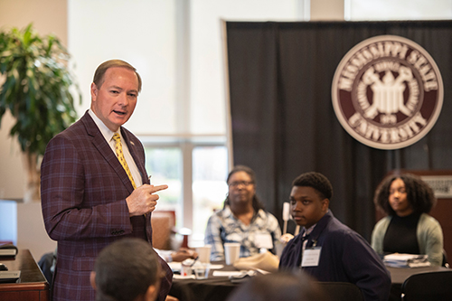 MSU President Mark E. Keenum speaks to students listening around him.