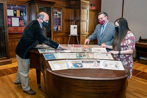 MSU Interim Dean of Libraries Tommy Anderson, from left, MSU Libraries Associate Dean Stephen Cunetto, and Assistant Professor and Manuscripts Librarian Carrie Mastley look over items from the Janice Cleary Sheet Music Collection spread across the top of a piano.