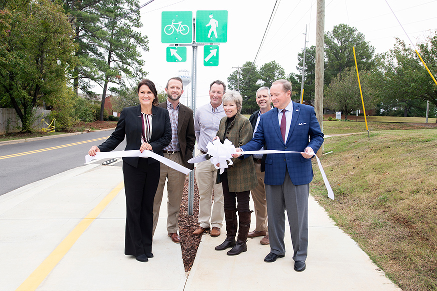 Officials cut a ribbon in front of the new Locksley Way multiuse path.