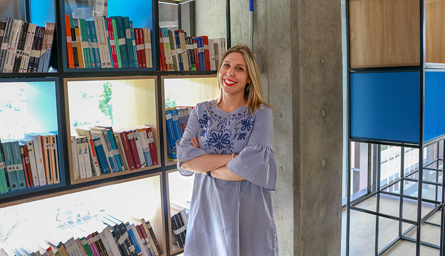 Environmental portrait of Lourdes Cardozo-Gaibisso near a bookshelf