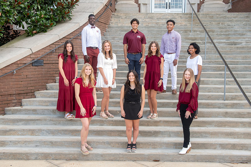 A group of 10 students representing the 2021 class of Luckyday Scholars at MSU stand on the steps of Lee Hall.