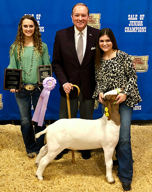 Mississippi State University President Mark E. Keenum was part of a group of buyers who successfully bid for the Mississippi Bred Reserve Grand Champion heavyweight goat shown by 4-Her Cassidy Turbville, right, pictured with Keenum and her sister Bailey Turbville, an MSU student. The Turbville sisters are from Madison.