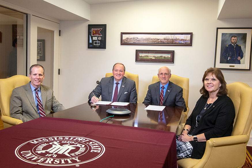 MSU leaders celebrate the MOU signing with Hinds Community College in a conference room.