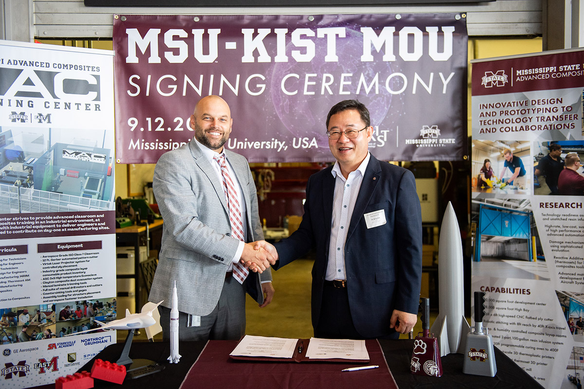 Chris Bounds and Jin Sang Kim shake hands after signing a memorandum of understanding