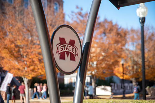 Picture of an MSU logo with fall leaves in the background