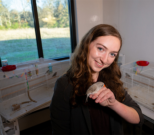 Madison Brode holding a Zebra finch
