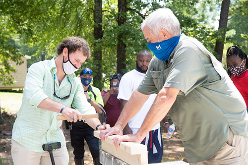 Retired Army captain Matt Savage drives a nail into a piece of wood held by John Breazeale of Starkville Area Habitat for Humanity.