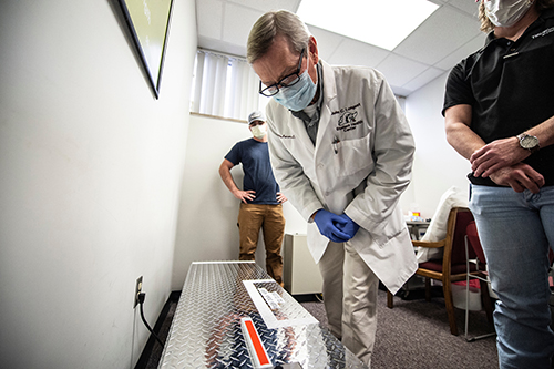 Dr. Philip Pearson looks at the UV sterilization device built by MSU students.