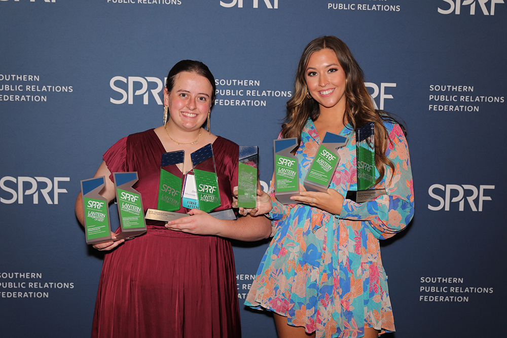 Zoie Henson and Sarah Colvert hold several award trophies