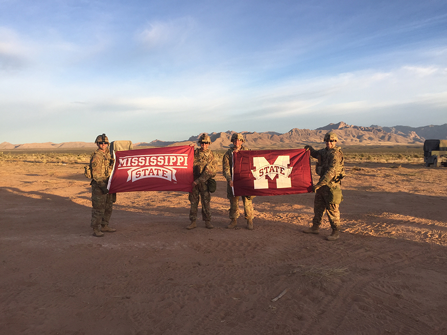 Members of the Mississippi Army National Guard’s 155th Armored Brigade Combat Team wave Mississippi State flags during training at Fort Bliss, Texas in April. The picture was taken to show support for the MSU women’s basketball team during its run to the  NCAA Final Four. (Submitted photo)