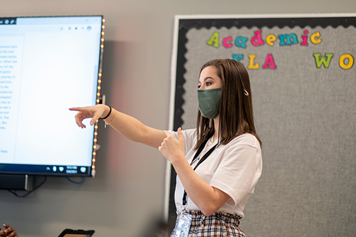 A student teacher leads a lesson in a middle school classroom