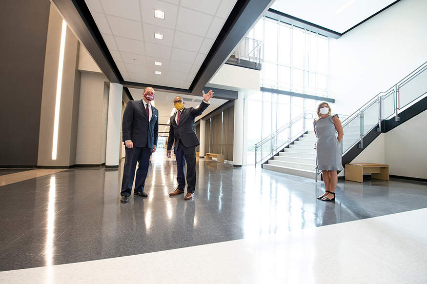 Mark Keenum, Eddie Peasant and Julie Kennedy speak in the atrium of the Partnership Middle School