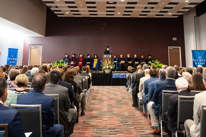 Honorees and officials at the Phi Beta Kappa Society’s Gamma of Mississippi Chapter installation and new member induction ceremony at Mississippi State University on April 2 included, from left, Shackouls Honors College Dean Christopher Snyder; Professor of English Matthew Little; Associate Professor of Chemistry Nickolas Fitzkee; Professor of Psychology Thomas Carskadon; Associate Professor of Anthropology and Middle Eastern Cultures Molly Zuckerman; Professor of English Robert West (at podium); Frederick M. Lawrence, Phi Beta Kappa Secretary/CEO (not pictured); Lynn Pasquerella, Phi Beta Kappa Society President and Association of American Colleges and Universities President; MSU President Mark E. Keenum; Provost and Executive Vice President Judy Bonner; College of Arts and Sciences Dean Rick Travis; renowned art director and designer Myrna Colley-Lee; and retired physician, philanthropist and MSU alumnus Dr. Richard Holmes. Also, not pictured is retired MSU Professor Robert Wolverton. Best-selling author and MSU alum John Grisham and MSU Rhodes Scholar Donald “Field” Brown also were honored but were unable to be present. (Photo by Logan Kirkland)